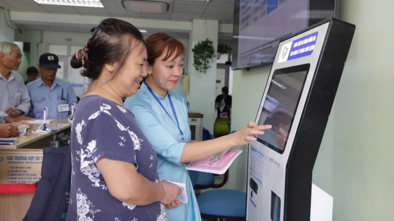 کارکنان بیمارستان دونگ دا (هانوی) مردم را در مورد استفاده از فناوری دیجیتال برای ثبت نام در معاینات و درمان پزشکی راهنمایی میکنند. (عکس از هوی هوانگ)