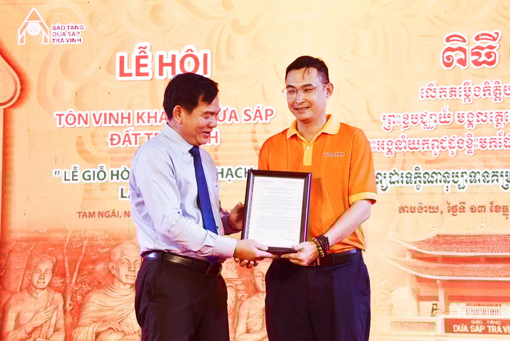 ທ່ານ ເຢືອງຮວ່າງຊຳ (ເບື້ອງຊ້າຍ) ຫົວໜ້າພະແນກວັດທະນະທຳ, ກິລາ ແລະ ທ່ອງທ່ຽວ ໄດ້ນຳສະເໜີການຕັດສິນໃຈຮັບຮອງພິພິທະພັນໝາກພ້າວຂີ້ເຜີ້ງ ຈ່າວິງ ເປັນສະຖານທີ່ທ່ອງທ່ຽວທີ່ໂດດເດັ່ນໃນເຂດທົ່ງພຽງແມ່ນ້ຳຂອງ.