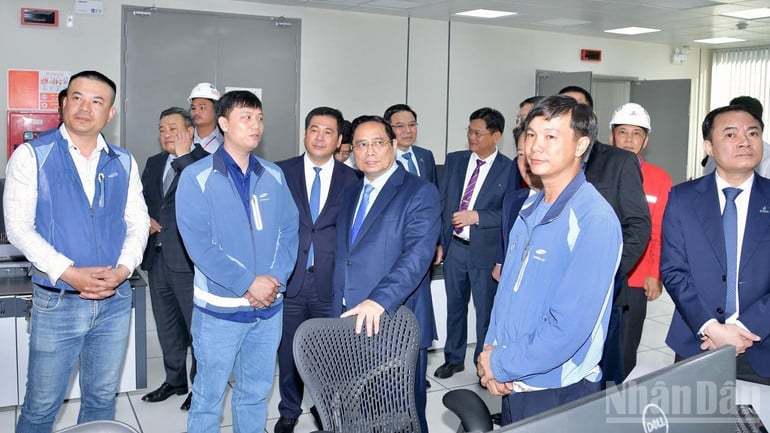 លោកនាយករដ្ឋមន្ត្រី ផាម មិញឈីញ ជួបពិភាក្សាជាមួយវិស្វករប្រតិបត្តិការនៅក្នុងបន្ទប់ត្រួតពិនិត្យកណ្តាលនៃរោងចក្រថាមពលដើរដោយឧស្ម័ន ញ៉ុងត្រាច ៣ និង ញ៉ុងត្រាច ៤។ (រូបថត៖ ថាញ់យ៉ាង)