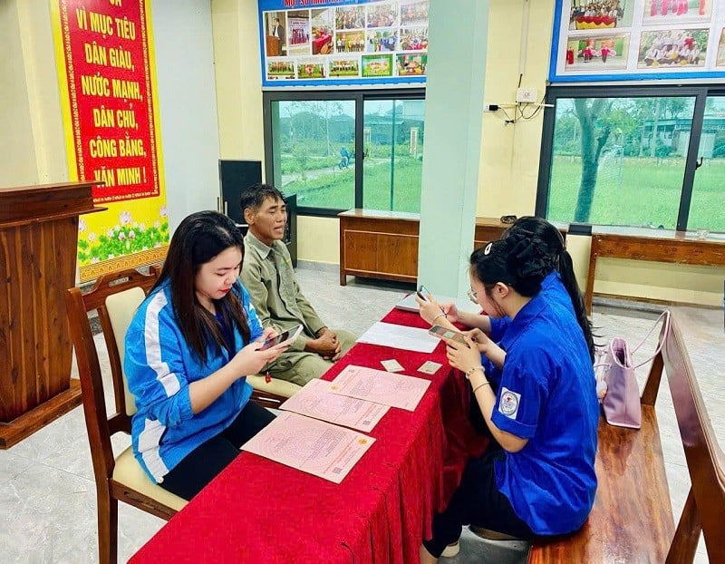 ສະມາຊິກສະຫະພັນຊາວໜຸ່ມໃນຕາແສງ ເກີມບິ່ງ, ແຂວງຮ່າຕິ້ງ, ນຳພາປະຊາຊົນໃນການຕື່ມແບບຟອມສະໝັກທາງອອນລາຍ.