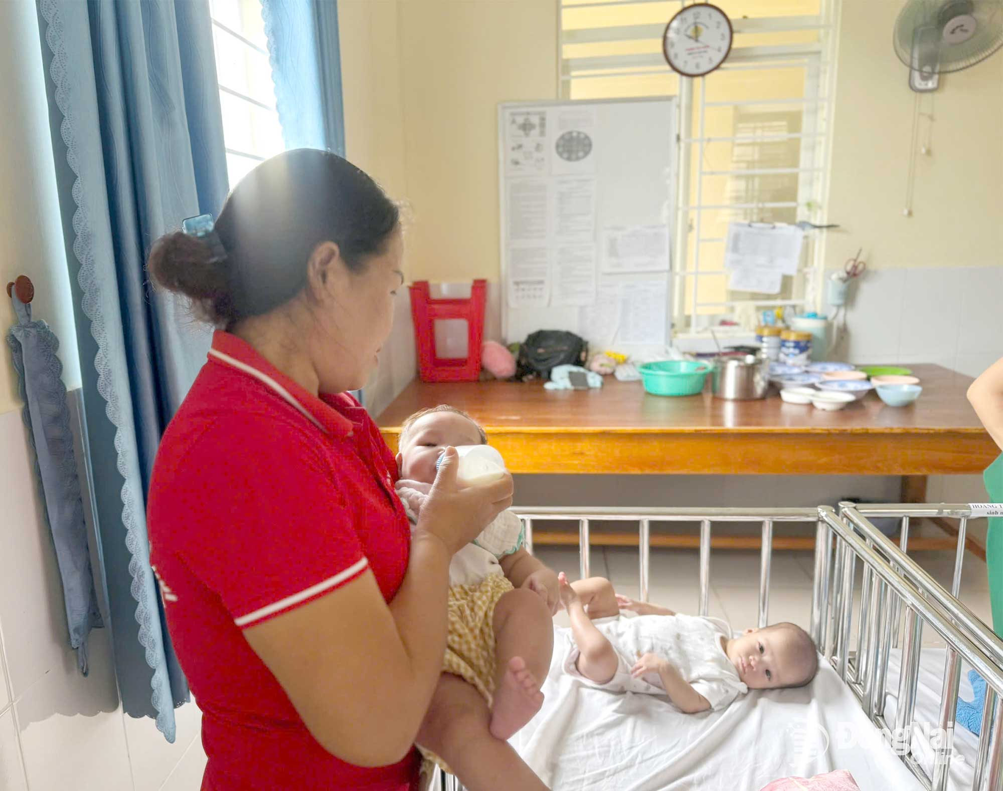 អ្នកស្រី ង្វៀន ធីហាញ ជាបុគ្គលិកនៅមជ្ឈមណ្ឌលការងារសង្គម និងមូលនិធិការពារកុមារ នៃសង្កាត់តាមហៀប កំពុងមើលថែកុមារដែលត្រូវបានគេបោះបង់ចោល។ រូបថត៖ ប៊ិក ញ៉ាន