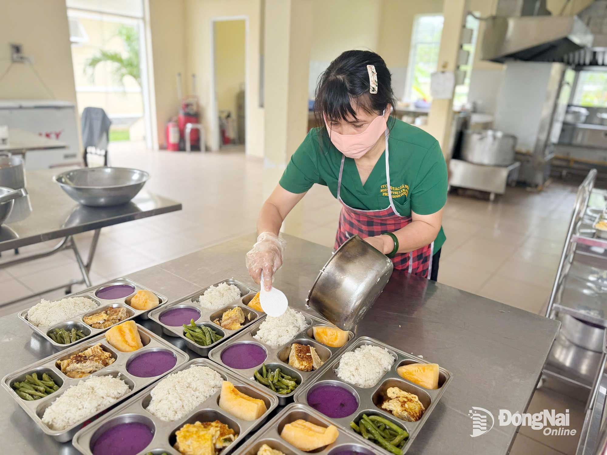 បុគ្គលិករៀបចំអាហារថ្ងៃត្រង់សម្រាប់អ្នកស្រុកនៃមជ្ឈមណ្ឌលការងារសង្គម និងមូលនិធិការពារកុមារ ក្នុងសង្កាត់តាមហៀប។ រូបថត៖ ប៊ីចញ៉ាន។