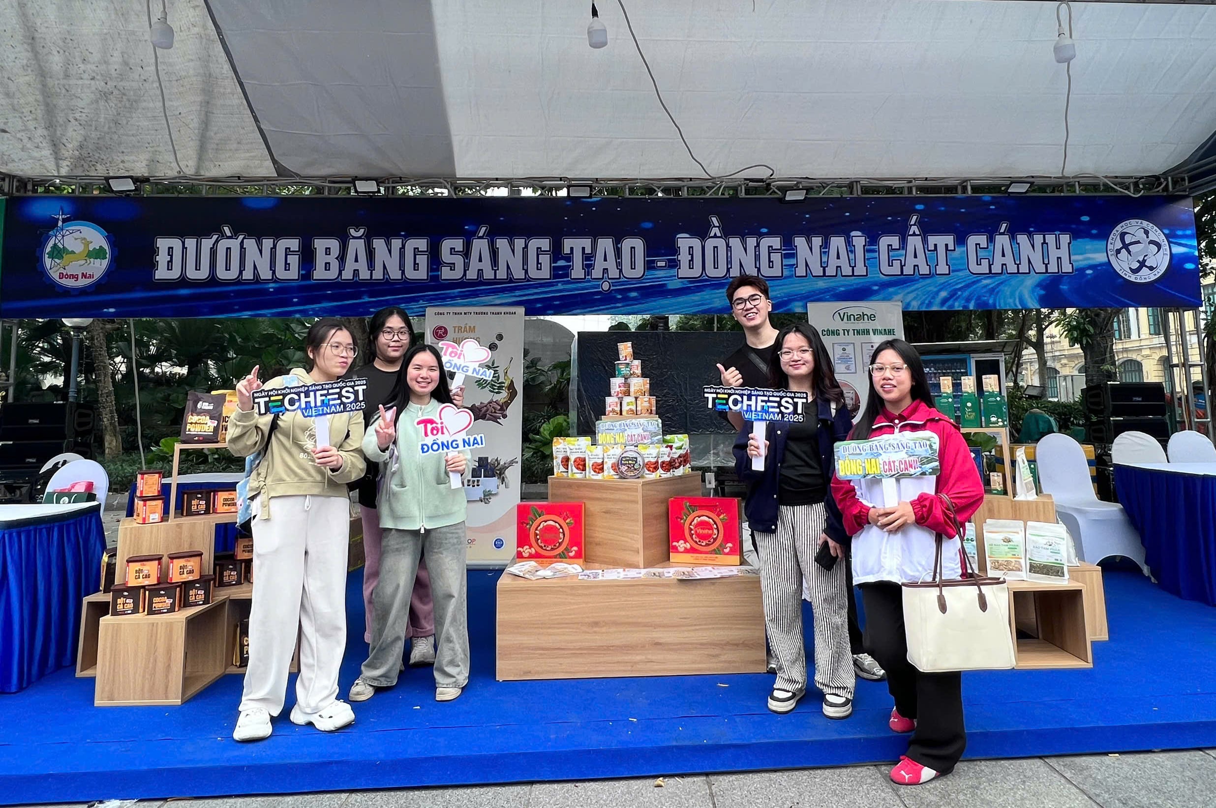 Młodzi ludzie meldują się przy stoisku prezentującym typowe produkty, produkty startupów i innowacje z prowincji Dong Nai na targach Techfest Vietnam 2025. Zdjęcie: Współpracownik.