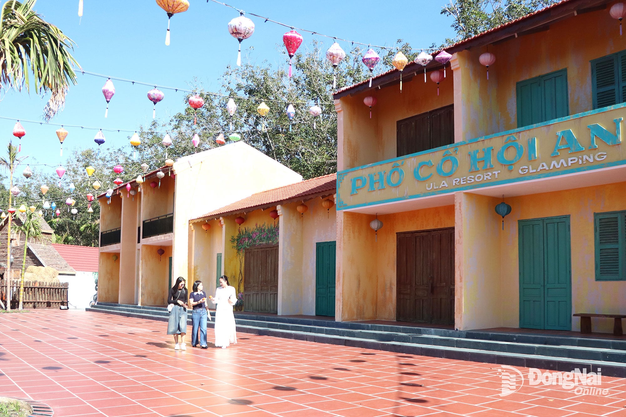 תיירים עושים צ'ק-אין באזור הבתים המסורתיים, חלק מאתר הנופש אולה גלאמפינג (קומונה טאן חאי). צילום: נגוק ליאן