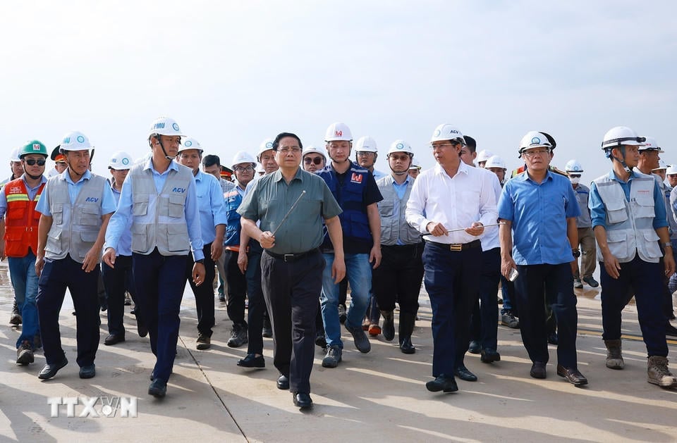 Премьер-министр Фам Минь Чинь осматривает взлетно-посадочную полосу и стоянку самолетов в рамках проекта международного аэропорта Лонг Тхань. (Фото: Дуонг Джанг/ВНА).