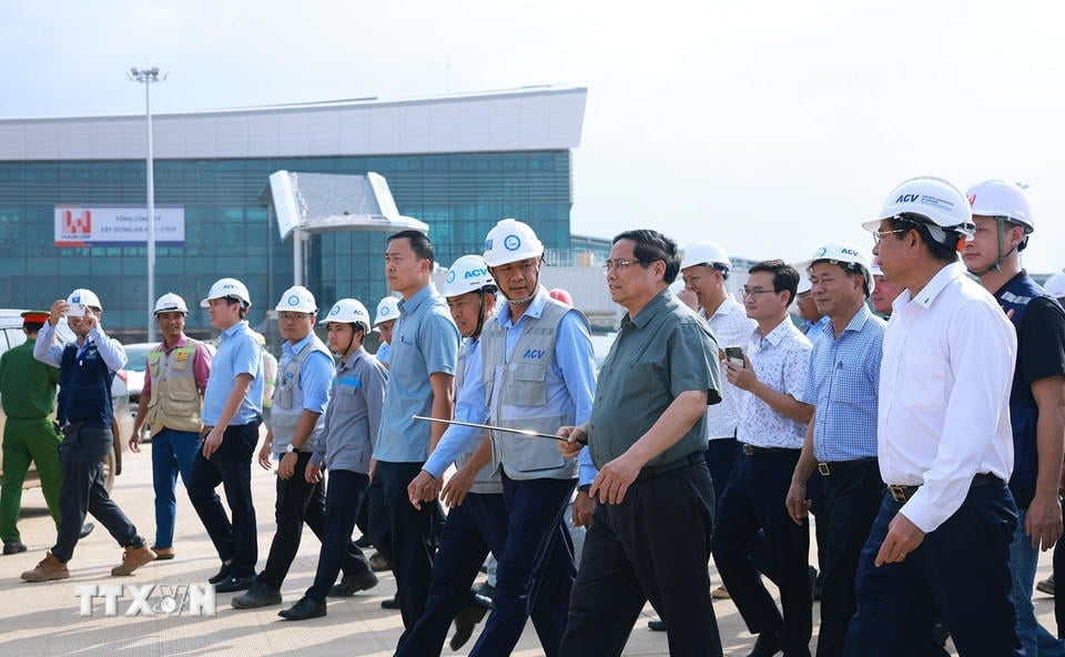 Премьер-министр Фам Минь Чинь осматривает взлетно-посадочную полосу и стоянку самолетов в рамках проекта международного аэропорта Лонг Тхань. (Фото: Дуонг Джанг/ВНА).