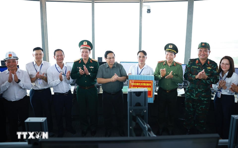 Премьер-министр Фам Минь Чинь вручает подарки официальным лицам и сотрудникам международного аэропорта Лонг Тхань. (Фото: Дуонг Джанг/ВНА).