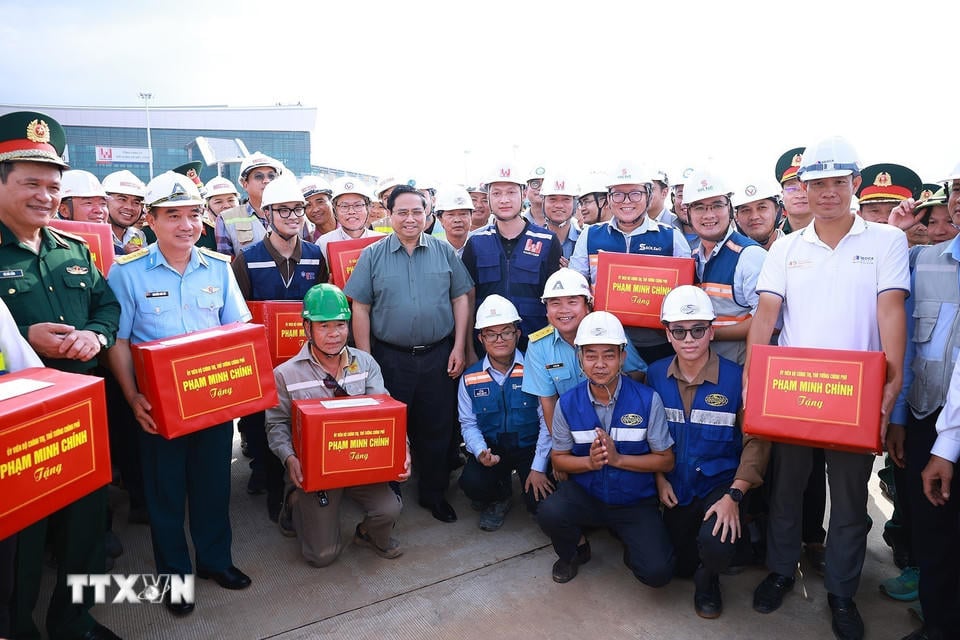 Премьер-министр Фам Минь Чинь вручает подарки строительным подразделениям проекта международного аэропорта Лонг Тхань. (Фото: Дуонг Джанг/ВНА).