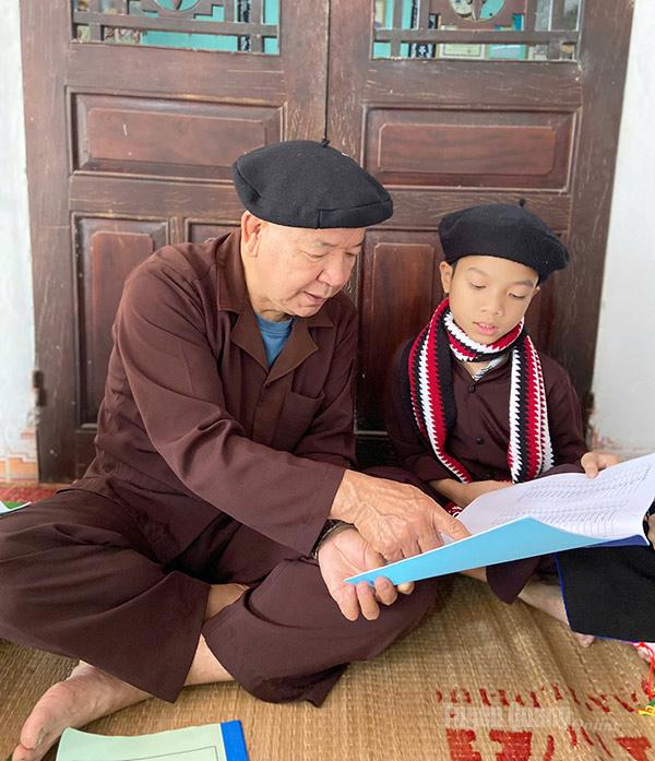 Lidový umělec Hoang Luc Thai, vedoucí pěveckého klubu Son Nam San Diu Soong Co, učí studenty psát a číst v San Diu.