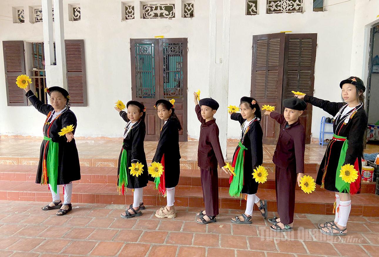 Lidový umělec Nguyen Thi Hong Chinh z pěveckého klubu Son Nam Soong Co San Diu v obci Son Thuy vede děti k nácviku tance.