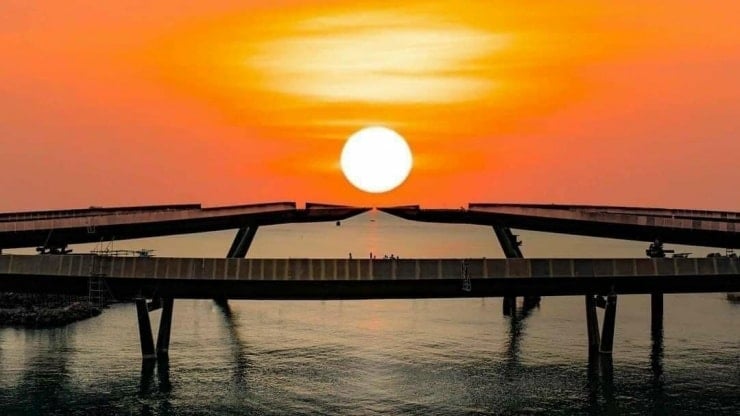 منظر بانورامي لجسر القبلة يمتد إلى البحر تحت غروب الشمس.