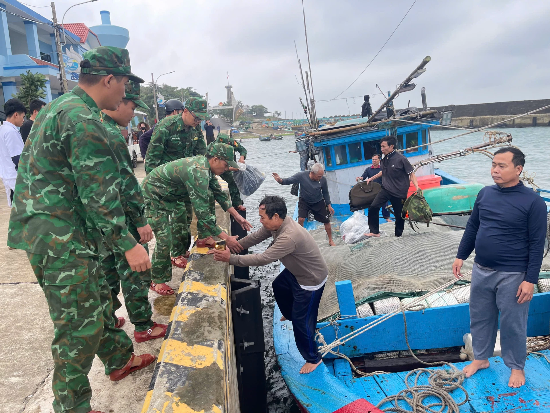 មន្ត្រីឆ្មាំព្រំដែនមកពីស្ថានីយ៍ឆ្មាំព្រំដែន Con Co ជួយនាំយកសមាជិកនាវិកនៃនាវា QT-90559-TS ដែលបានលិចនៅសមុទ្រមកច្រាំង - រូបថត៖ DV
