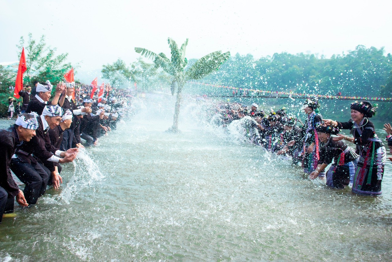 लाओस के बुन वोक नाम त्योहार में सौभाग्य के लिए पानी छिड़कने की रस्म। Nghi thức té nước cầu may trong lễ hội Bun Vốc Nặm của dân tộc Lào.