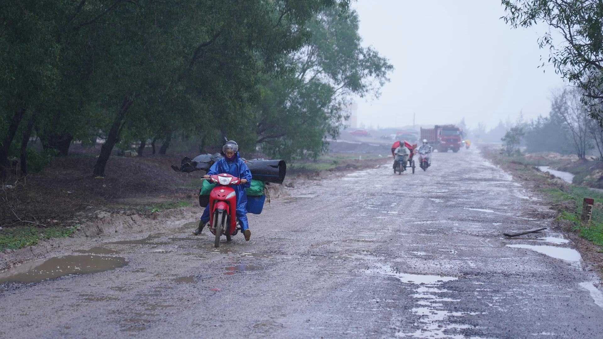 ផ្ទៃផ្លូវពោរពេញទៅដោយរណ្ដៅ និងភក់នៅពេលភ្លៀងធ្លាក់ ដែលធ្វើឱ្យអ្នកធ្វើដំណើរពិបាក - រូបថត៖ ឡេ ទ្រឿង
