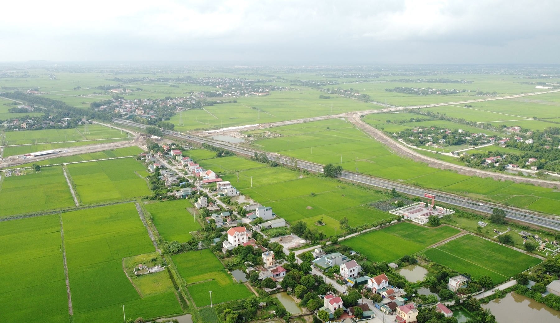 Pohled na městskou oblast v provincii Ninh Binh s mnoha stromy a budovami.