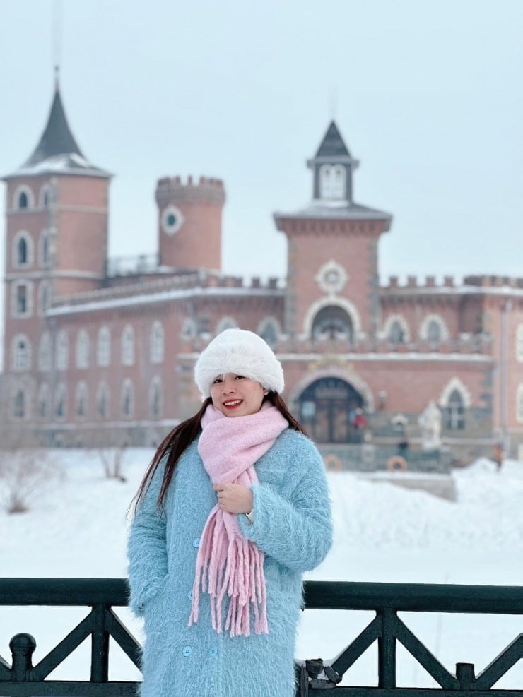 Vietnamští turisté, teple oblečení, zažívají zimu v Charbinu.