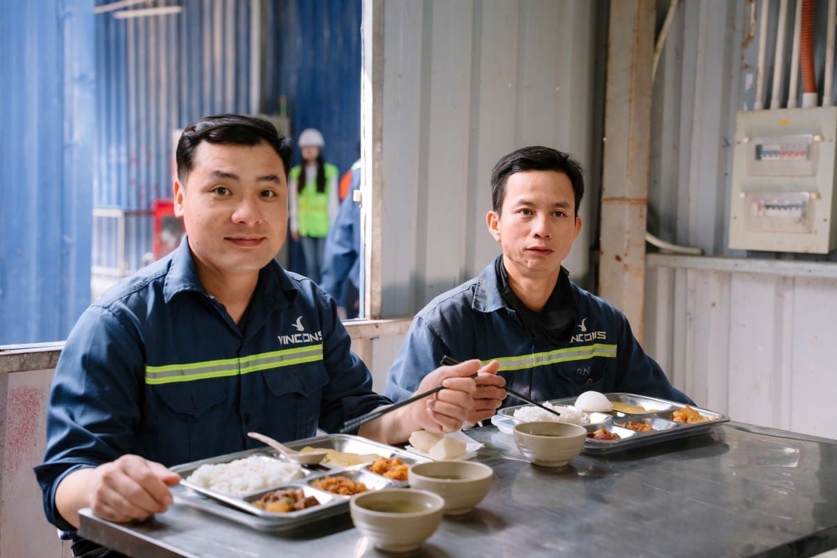 พนักงานที่ไซต์ก่อสร้างของ VinCons ได้รับการรับประกันที่พักและอาหารทุกวัน ภาพ: Vingroup Làm việc tại công trường của VinCons, công nhân được đảm bảo chỗ ở, bữa ăn mỗi ngày. Ảnh: Vingroup.