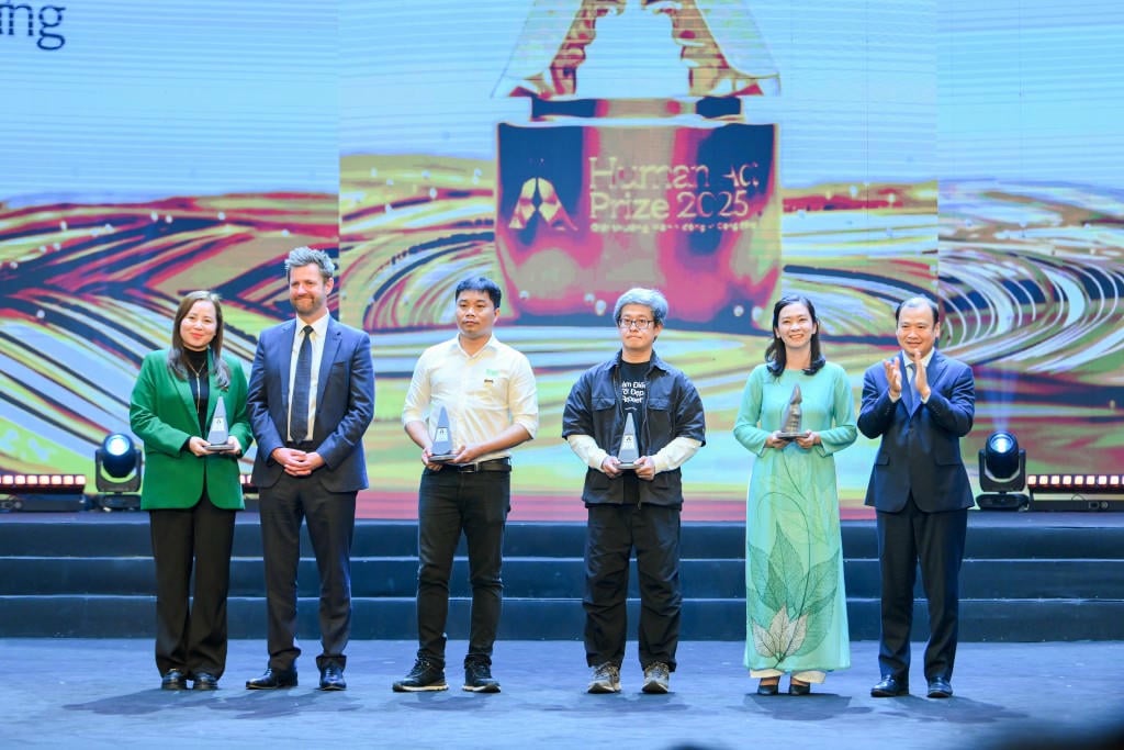 Товарищ Лай Суан Мон — член Центрального комитета партии, заместитель председателя Постоянного комитета Центрального управления пропаганды и массовой мобилизации — вручает награду за настойчивость проектам (фото предоставлено Организационным комитетом).