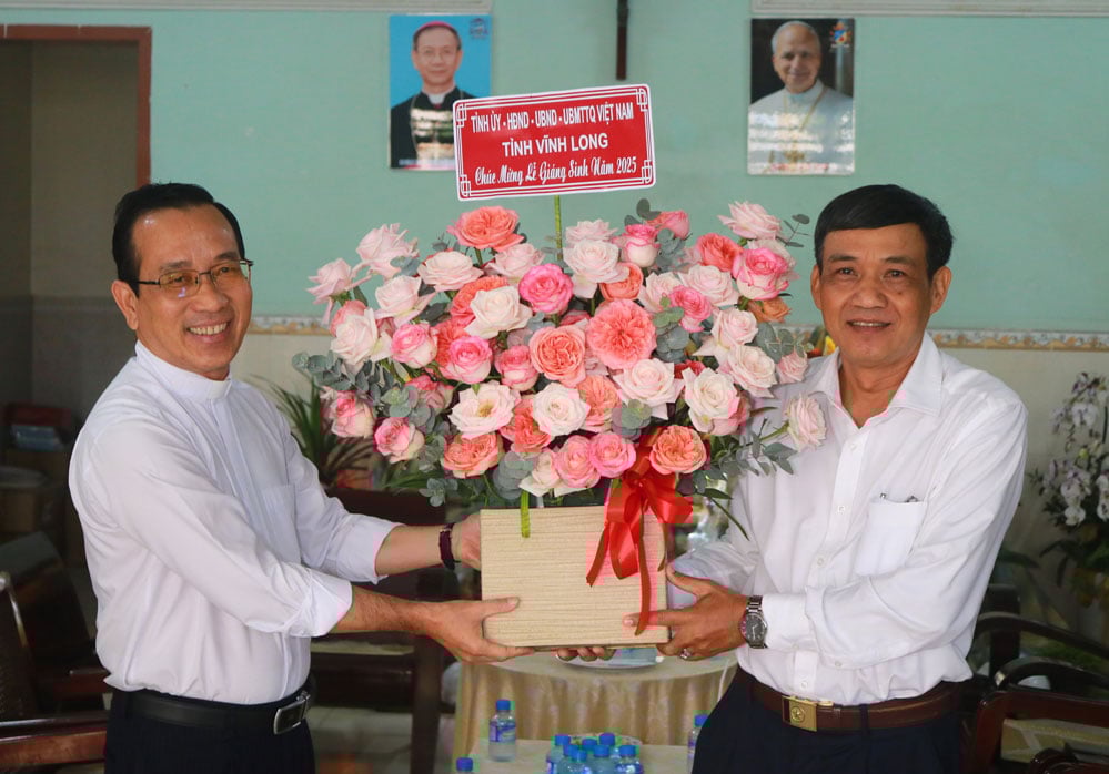 អនុប្រធានគណៈកម្មាធិការរណសិរ្សមាតុភូមិវៀតណាមខេត្តកៀនយ៉ាងប្រគល់ផ្កាអបអរសាទរវិហារ និងលោកបូជាចារ្យង្វៀនង៉ុកតឹន (សង្កាត់ឡុងចូវ)។ រូបថត៖ ទួយយ៉ែតង៉ា។