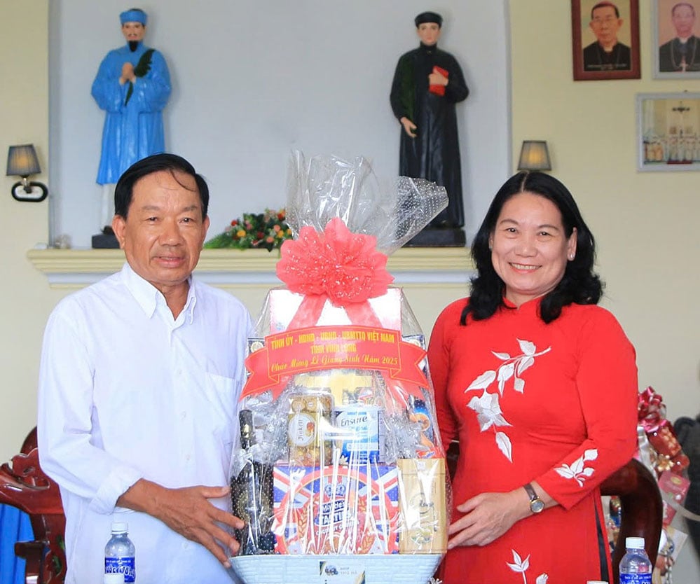 نایب رئیس کمیته مردمی استان - نگوین تی بی مویی، هدایای کریسمس را به پدر نگوین ون تان - کشیش کلیسای کاتولیک مک باک - تقدیم می‌کند.