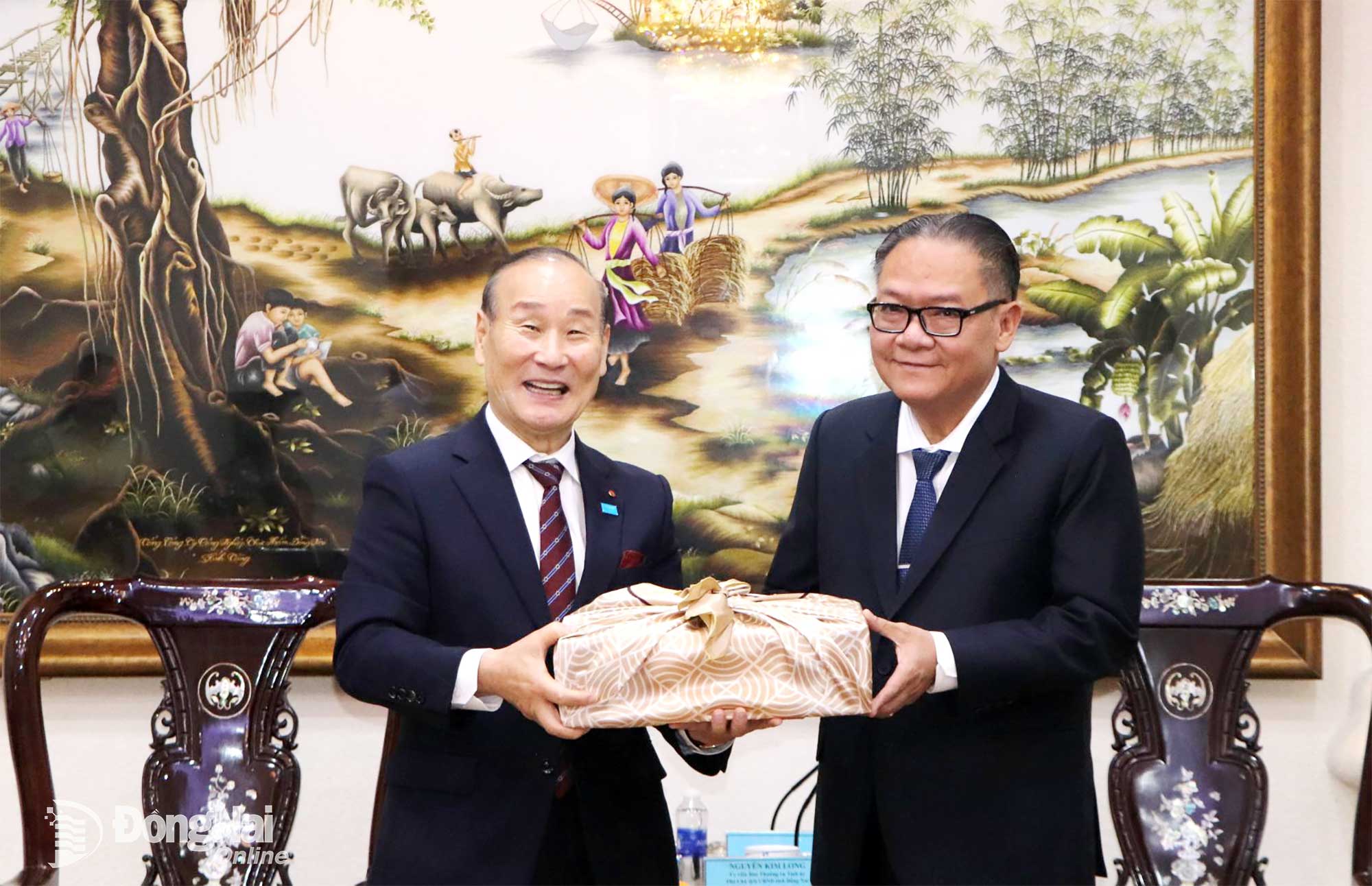 សមមិត្ត ង្វៀន គីមឡុង សមាជិកគណៈកម្មាធិការអចិន្ត្រៃយ៍នៃគណៈកម្មាធិការបក្សខេត្ត និងជាអនុប្រធានអចិន្ត្រៃយ៍នៃគណៈកម្មាធិការប្រជាជនខេត្តដុងណៃ ទទួលអំណោយរំលឹកវិញ្ញាណក្ខន្ធពីលោក ឆយ ប៊្យុងអូ។ រូបថត៖ ង៉ុកលៀន