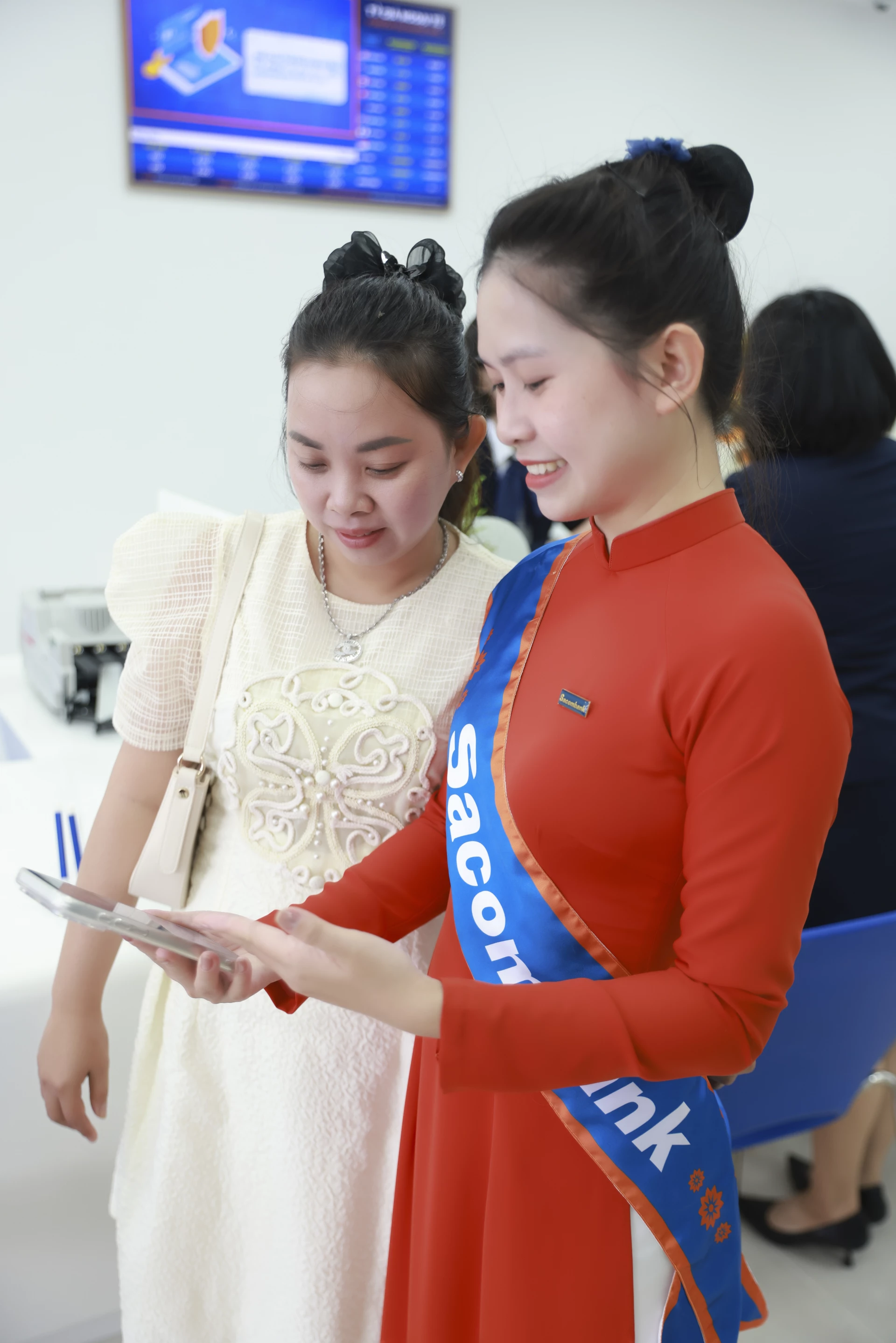 បុគ្គលិក Sacombank ណែនាំអតិថិជនអំពីរបៀបប្រើប្រាស់កម្មវិធីធនាគារឌីជីថល។