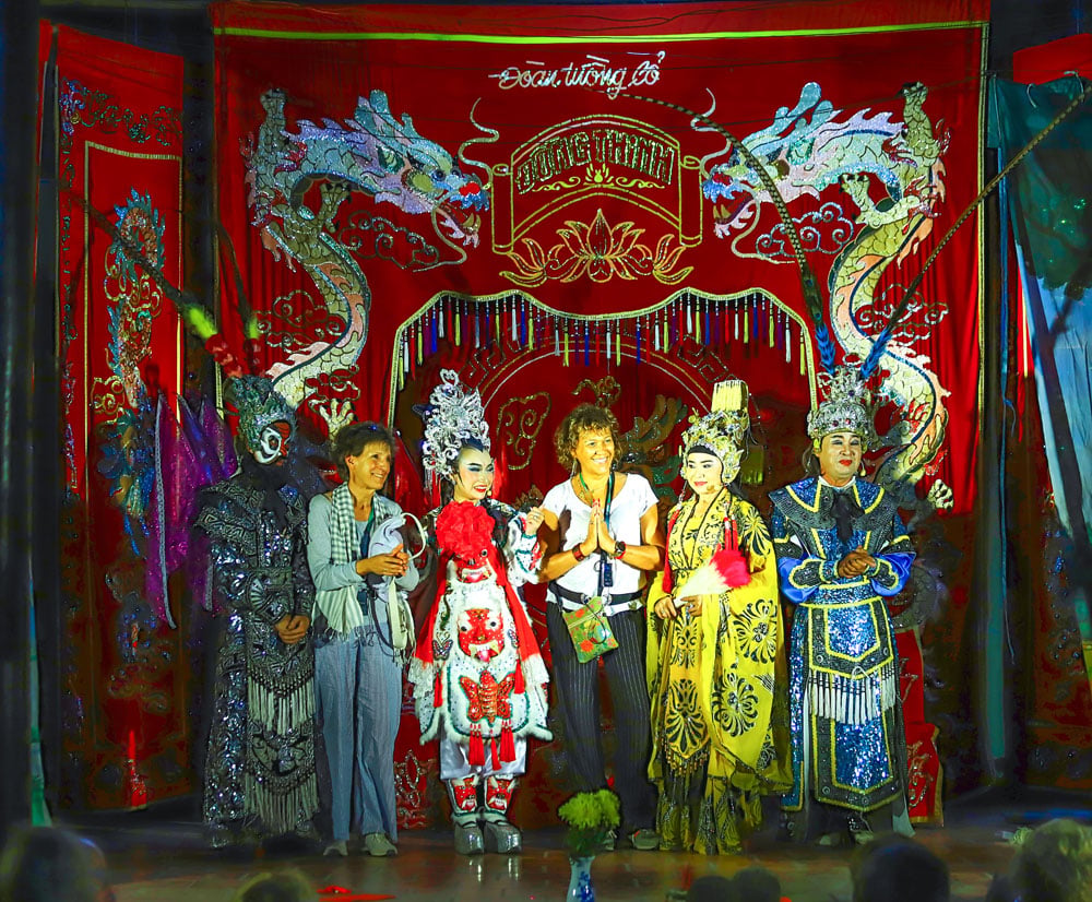 Foreign tourists take souvenir photos with the traditional Vietnamese opera (Hát Bội) artists.
