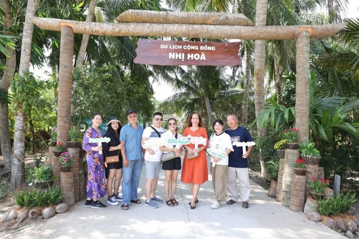 ភ្ញៀវទេសចរ​ចុះ​ឈ្មោះ​នៅ​ច្រក​ចូល​ភូមិ​ទេសចរណ៍​សហគមន៍​ញី​ហ្វា។