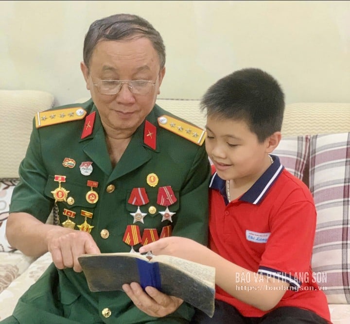 Cựu chiến binh Nguyễn Đức Lập,  phường Lương Văn Tri kể lại kỷ niệm thời kháng chiến cho cháu nội nghe