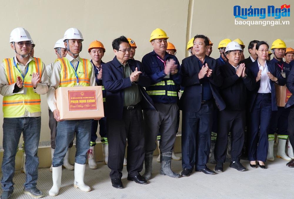 El primer ministro Pham Minh Chinh entrega obsequios a funcionarios y trabajadores en el sitio de construcción del proyecto de la autopista Quang Ngai - Hoai Nhon (Binh Dinh).