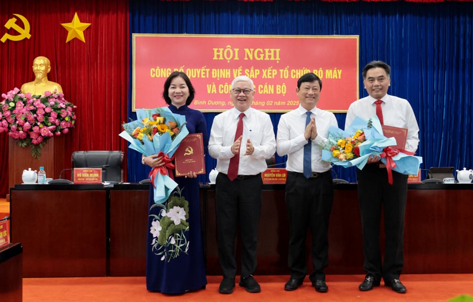 El secretario provincial del partido, Nguyen Van Loi, presentó la decisión y el presidente del Comité Popular Provincial, Vo Van Minh, entregó flores al Sr. Nguyen Loc Ha y a la Sra. Truong Thi Bich Hanh. Foto: Comité Organizador.