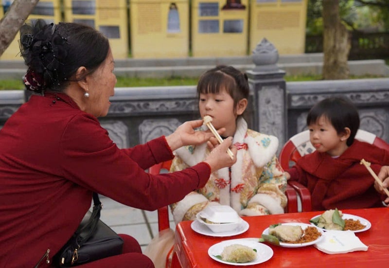 Les enfants sont très excités de manger du banh chung au festival.