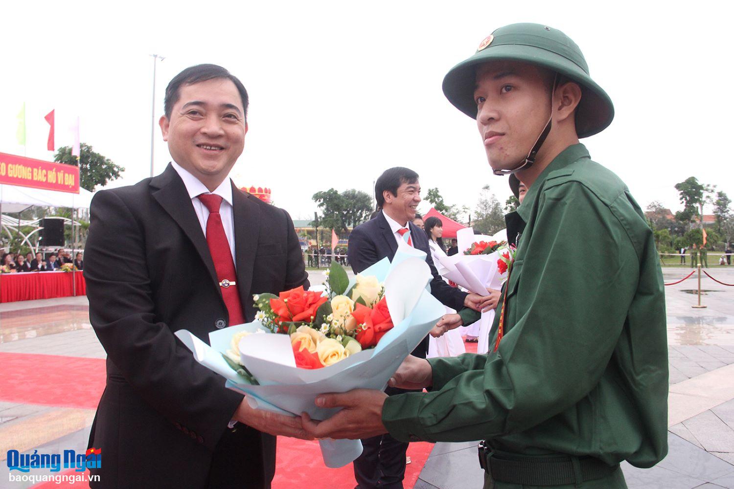 Bí thư Huyện ủy Nghĩa Hành Trần Đình Cảm tặng hoa chúc mừng các tân binh lên đường nhập ngũ. Ảnh: M.HOA