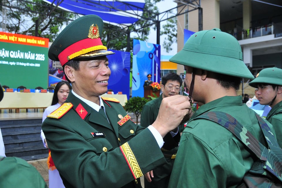 Oberst Nguyen Cong Anh, stellvertretender politischer Kommissar des Ho-Chi-Minh-Stadt-Kommandos, hat einem jungen Mann aus Bezirk 8 den Hut angeheftet, um ihn zum Eintritt in die Armee zu bewegen. Foto: Tan Tien.