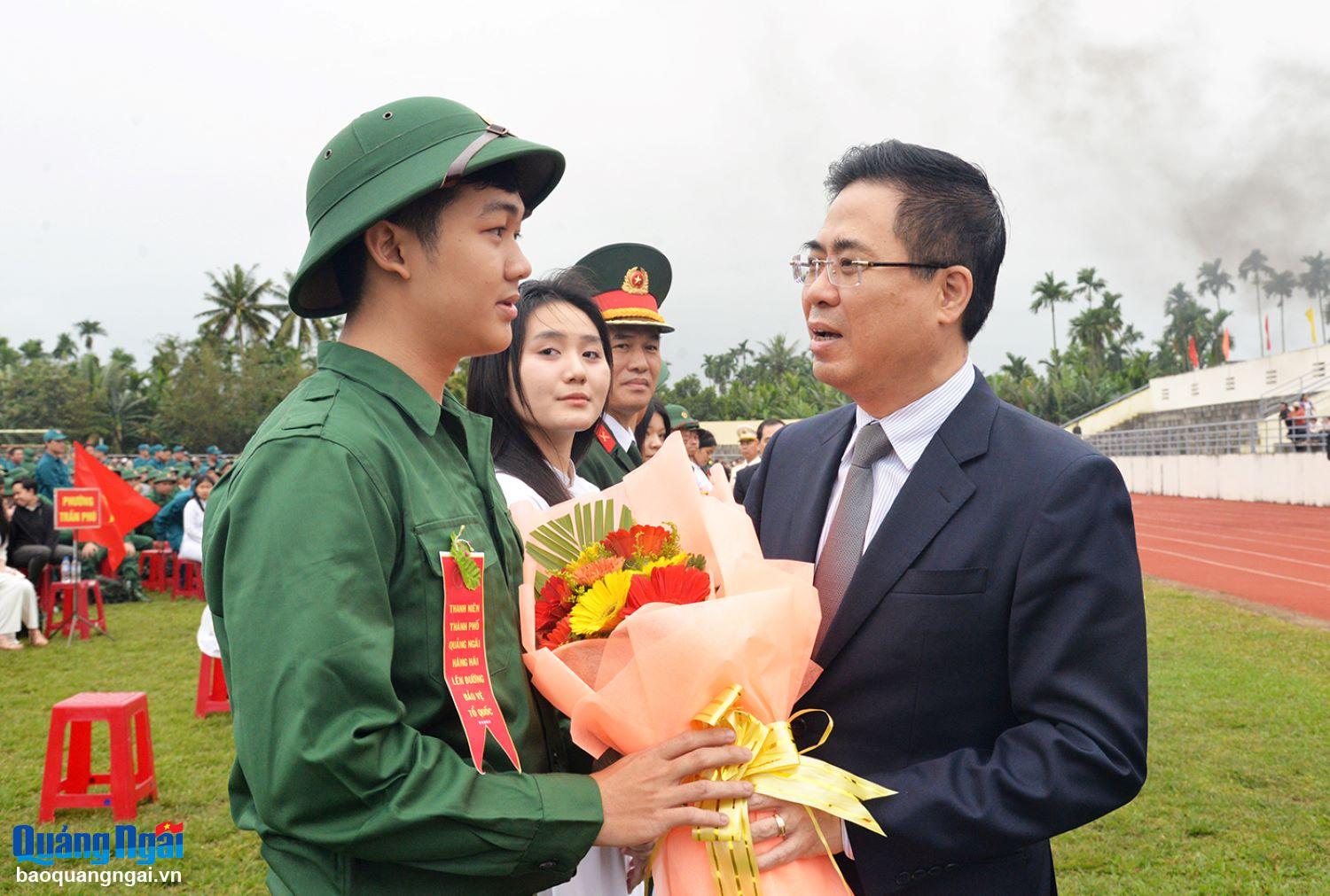 Phó Bí thư Tỉnh ủy, Chủ tịch UBND tỉnh Nguyễn Hoàng Giang tặng hoa động viên tân binh. Ảnh: T.PHƯƠNG