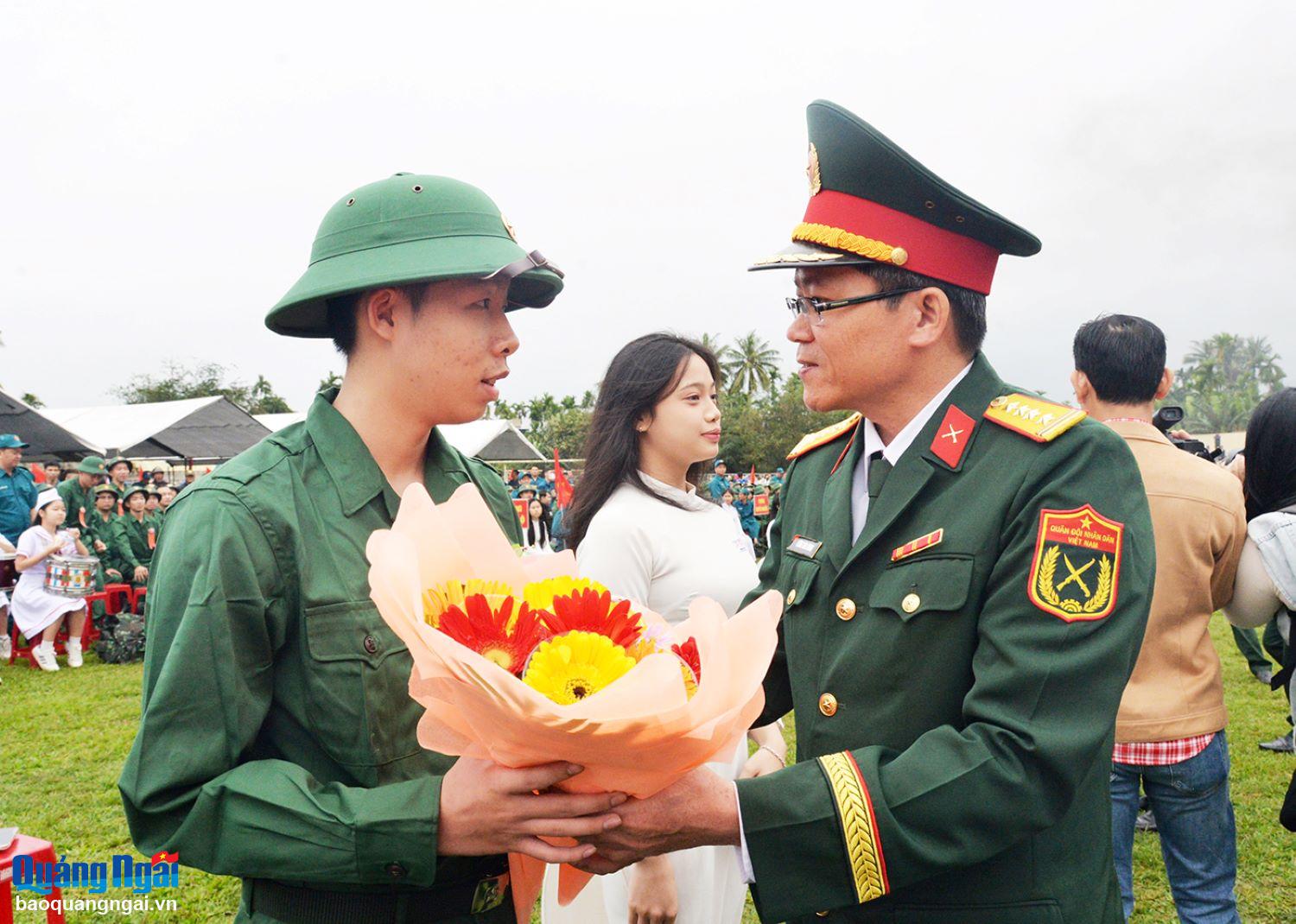 Đại tá Lương Đình Chung - Phó Chính uỷ Quân khu 5 tặng hoa, động viên tân binh. Ảnh: T.PHƯƠNG