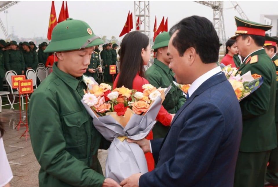 Thai Nguyen Provincial Party Secretary Trinh Viet Hung presents flowers to new recruits.