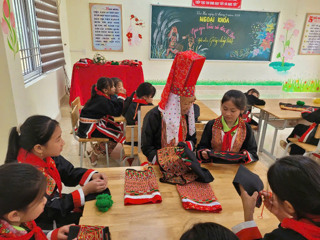 L'artisan Dieng Chong Senh enseigne aux élèves de l'école secondaire Quang Son pour les minorités ethniques l'artisanat traditionnel dans le cadre des cours parascolaires de l'école.