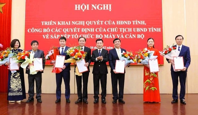 El Sr. Pham Dinh Nghi, presidente del Comité Popular Provincial de Nam Dinh, presentó la decisión y flores para felicitar a los líderes del Departamento de Finanzas después de la fusión. Foto: Duy Hung