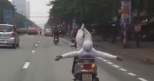 Man lets go of his hand and "does circus" with a motorbike running on the street