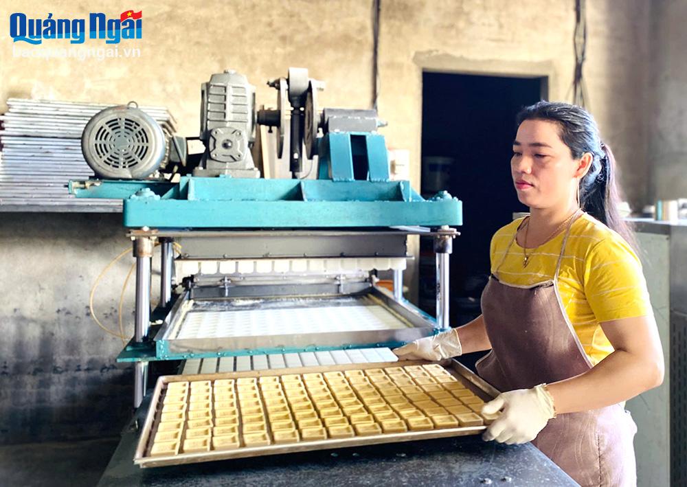 Mme Dang Thi Thiet, du village de Doan Ket, commune de Tinh An Dong (ville de Quang Ngai), utilise des machines modernes dans le processus de production de gâteaux de haricots verts.                Photo: HIEN THU