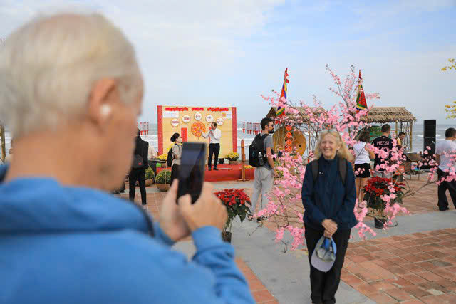 Les touristes capturent les souvenirs du Têt traditionnel sur la plage de Da Nang.