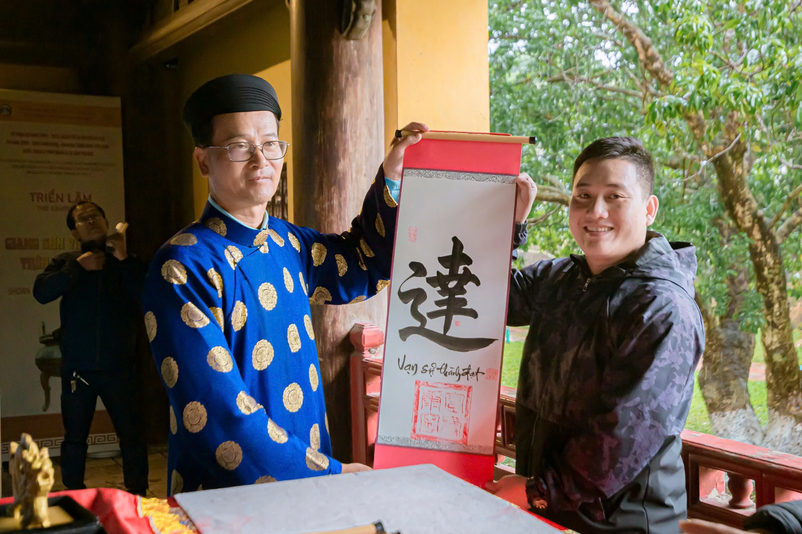 Tourists are given calligraphy at the flag-lowering ceremony in Hue Imperial Palace