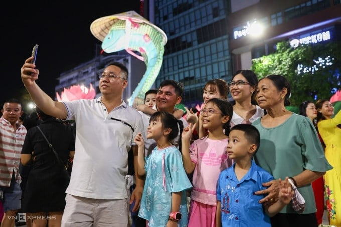 Les touristes visitent la rue des fleurs de Nguyen Hue à l'occasion du Têt At Ty. Photo : Quynh Tran