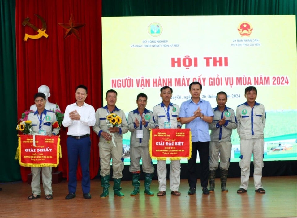 Giám đốc Sở NN&PTNT Hà Nội Nguyễn Xuân Đại và Bí thư Huyện ủy Phú Xuyên Nguyễn Xuân Thanh trao giải Đặc biệt và giải Nhất cho các đội thi trong hội thi “Người vận hành máy cấy giỏi vụ Mùa năm 2024”. Ảnh: Thu Phượng