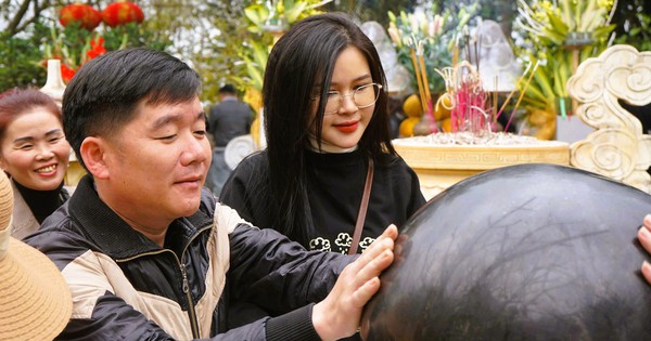 観光客は競ってお金を使い、ヌア山の聖なるツボにある石をこすります。