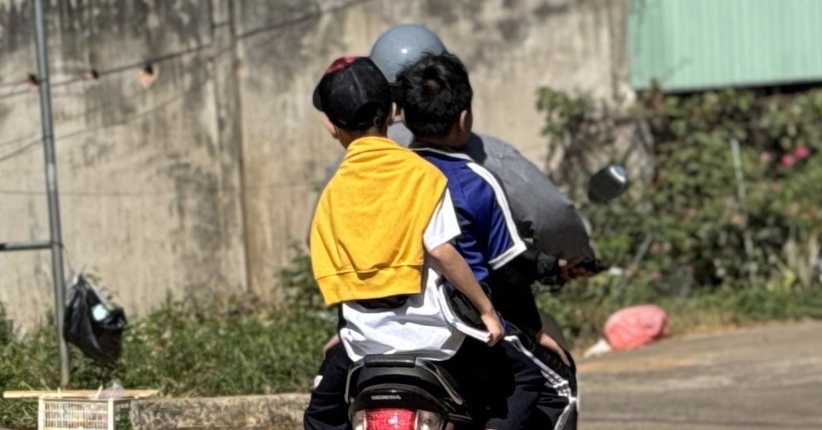 Todavía transportando a tres personas, sin casco, a toda velocidad frente a la puerta de la escuela