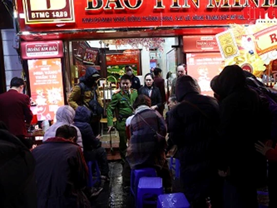 People lined up in the rain to buy gold for luck on God of Fortune Day