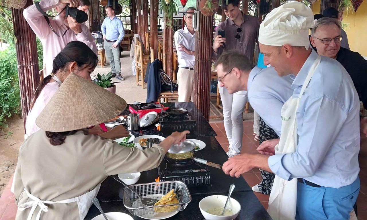 Delegates participate in a cooking experience at a restaurant in Tra Que vegetable village. Photo: QUOC TUAN