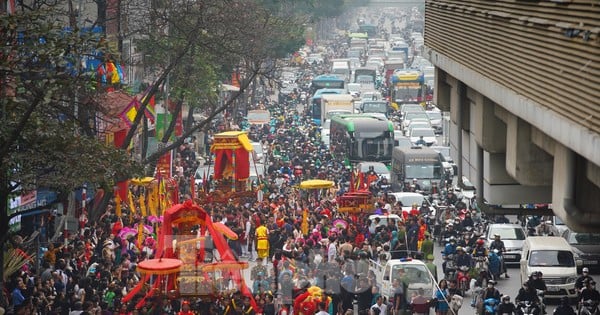 Mar de gente observando la procesión de 5 pueblos que crecen en medio de la calle de Hanoi